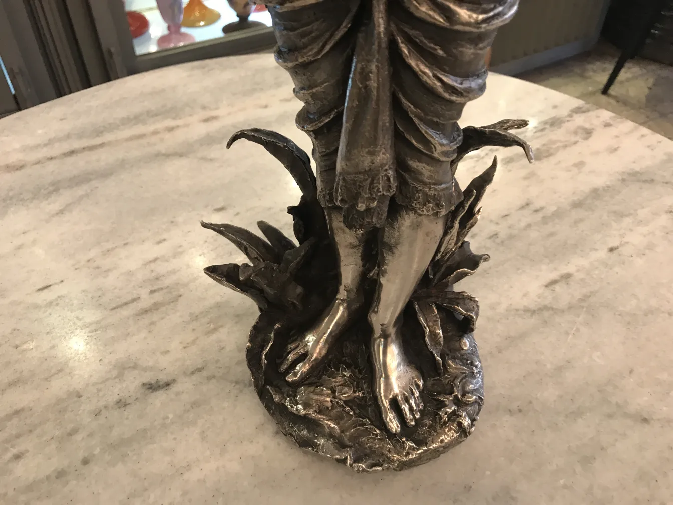 Antique sculpture of a figure on a natural base, realistic details.