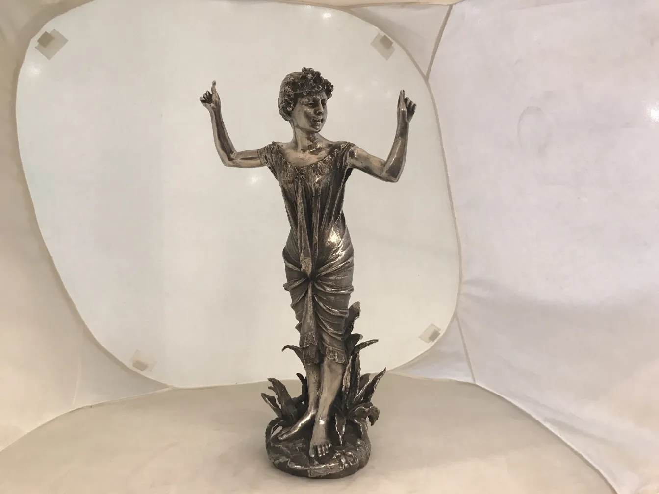 escultura antiga de mulher com os braços levantados em um ambiente claro