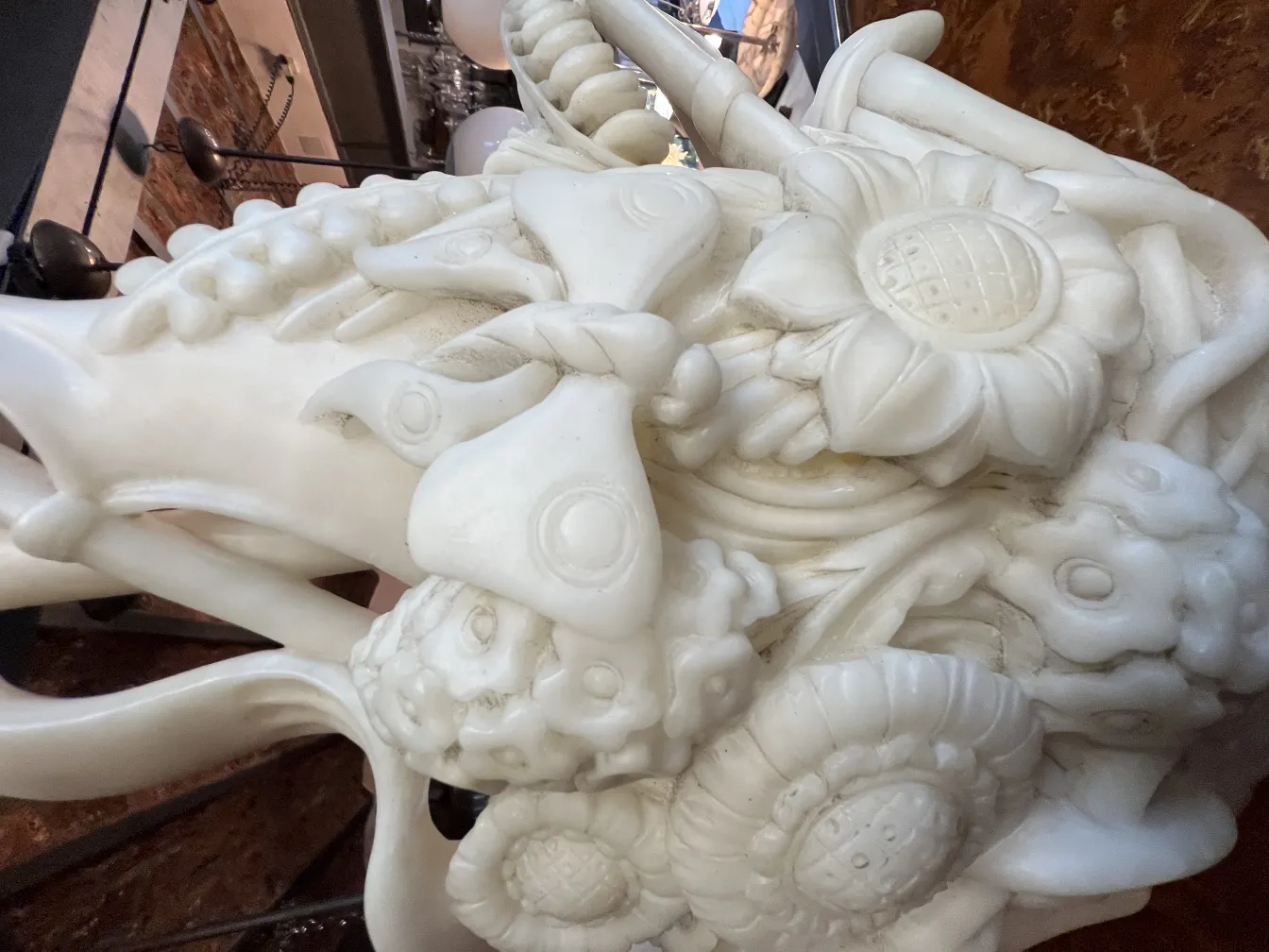 Reliefdetails einer antiken weißen Blumenskulptur.