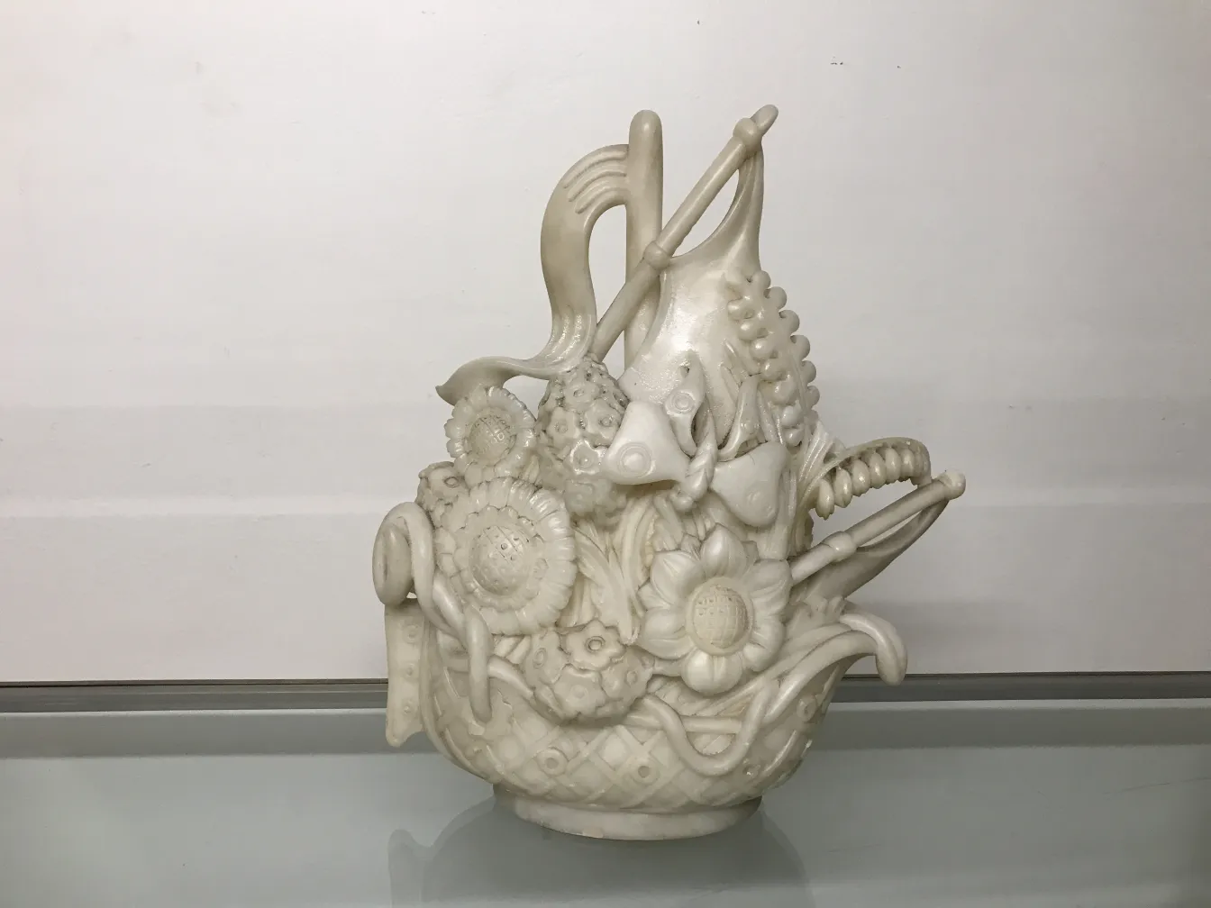 Antike Skulptur mit kunstvollem Relief von Fischen und Blumen.