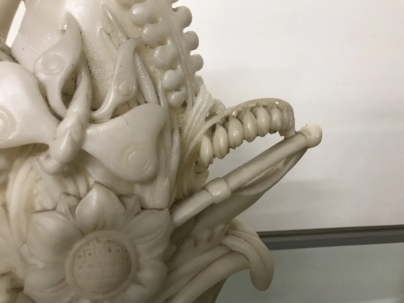 Scultura antica con intricati dettagli floreali e farfalle.