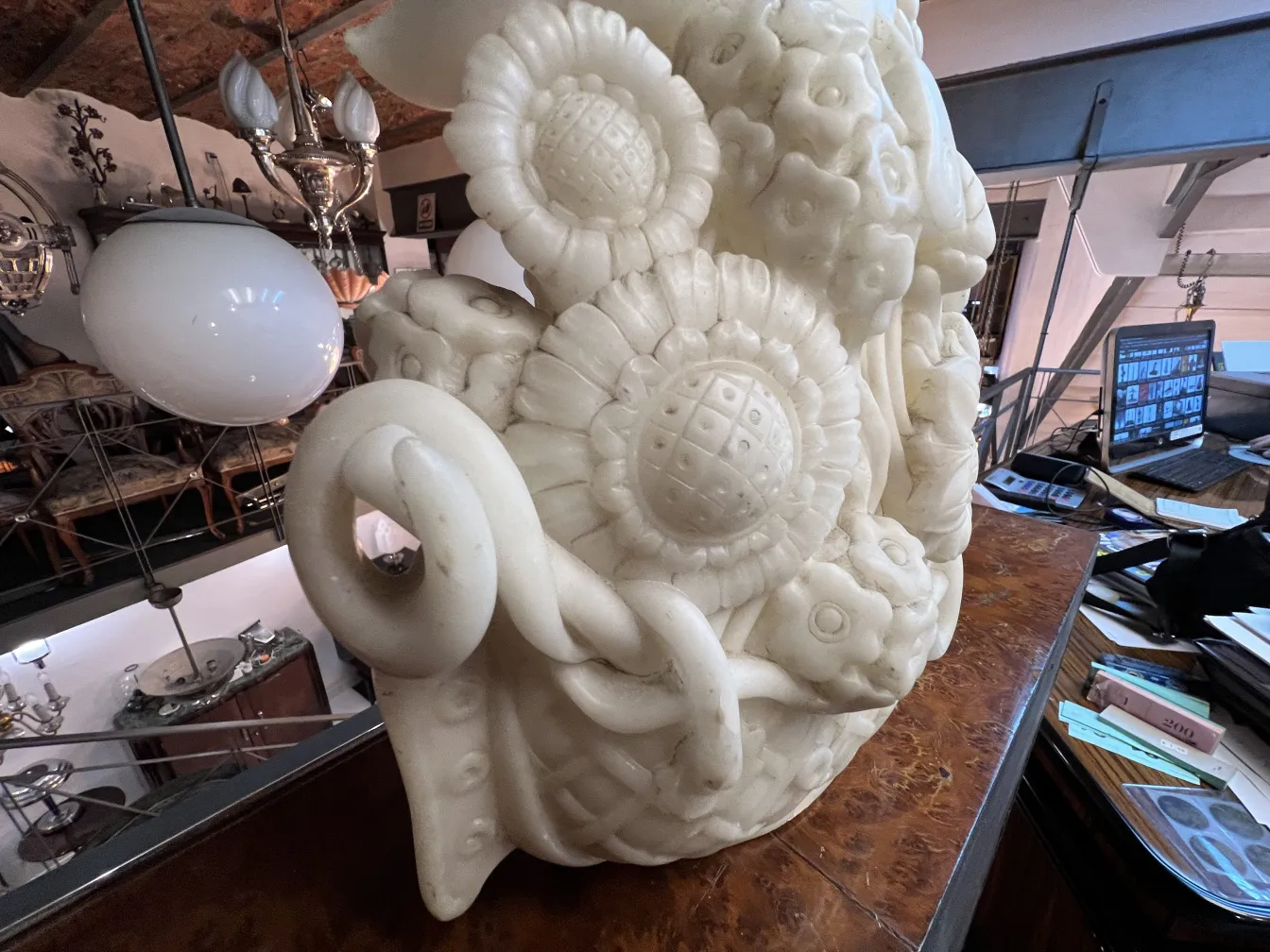 Sculpture antique avec des détails floraux dans un cadre vintage.