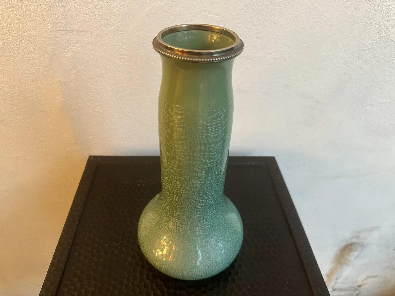 金属のディテールが施された古い緑の陶器の花瓶。