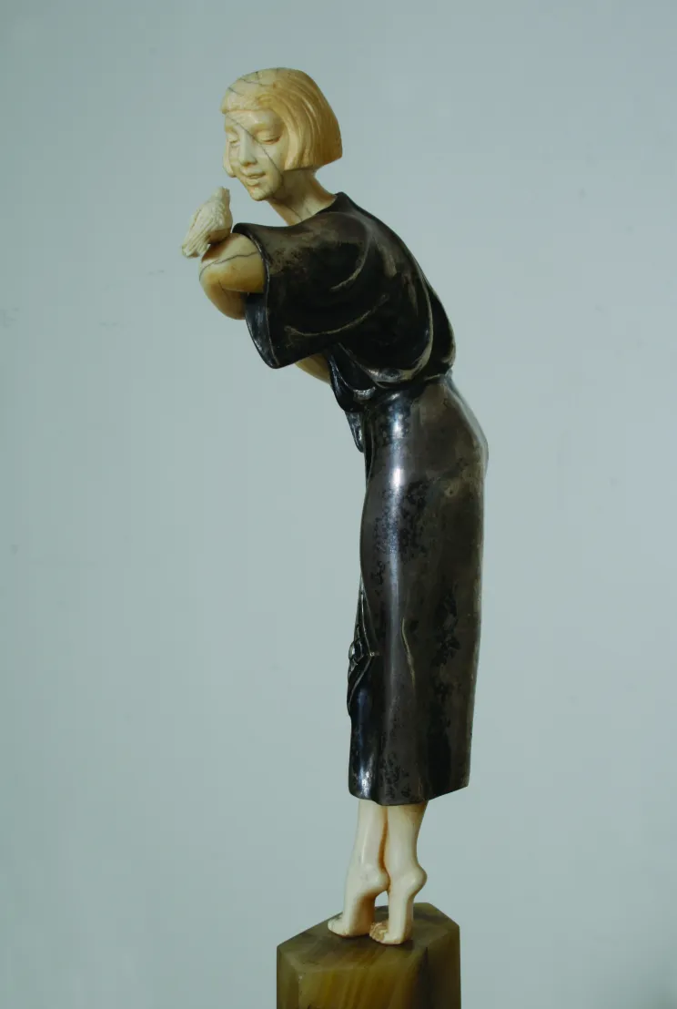 escultura antigua de mujer sosteniendo un pájaro, elegante perfil