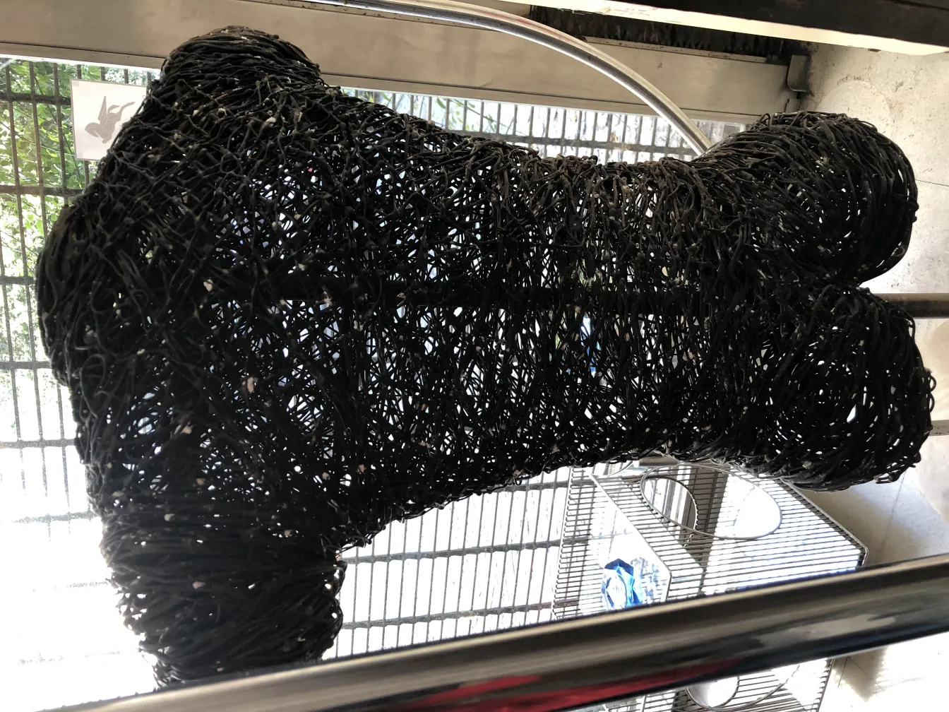 Black contemporary sculpture with abstract shape, modern setting.