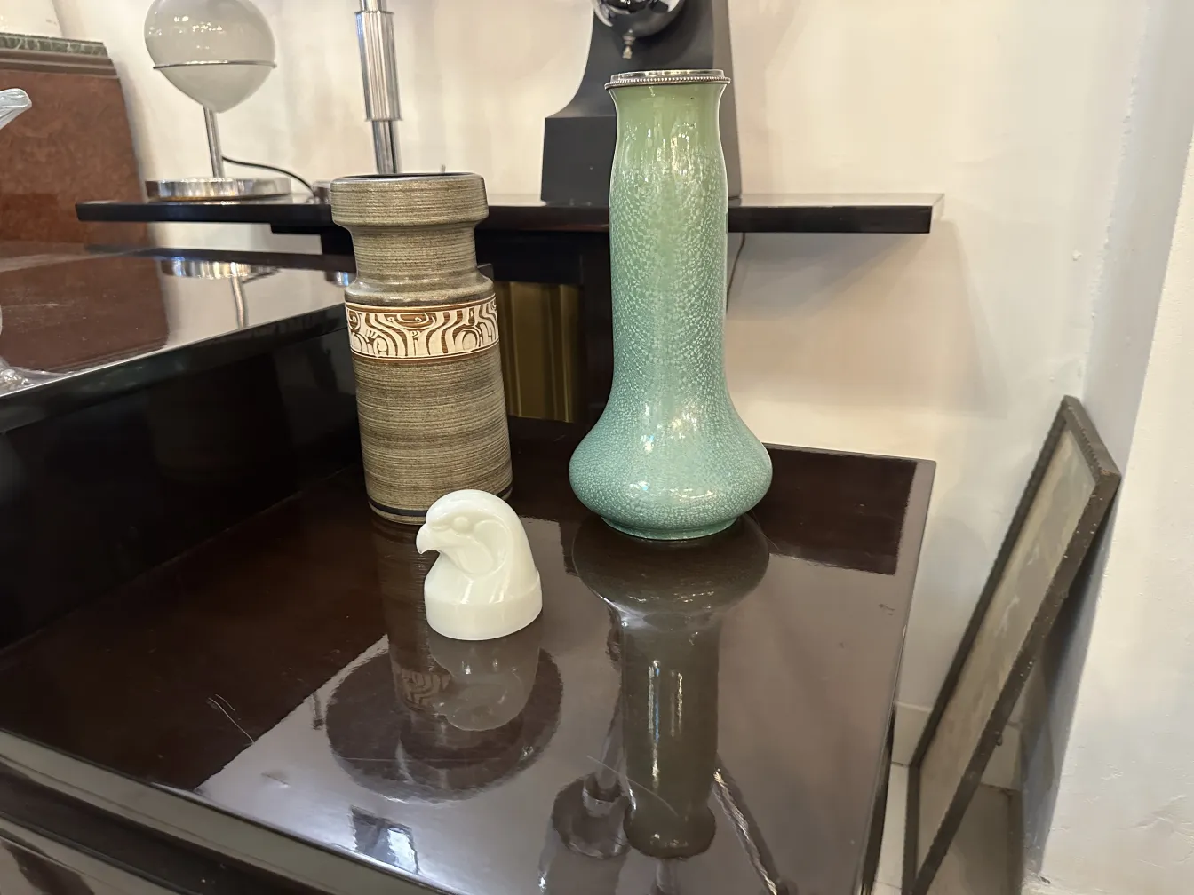 Jarrón de cerámica antigua en verde con figura decorativa.