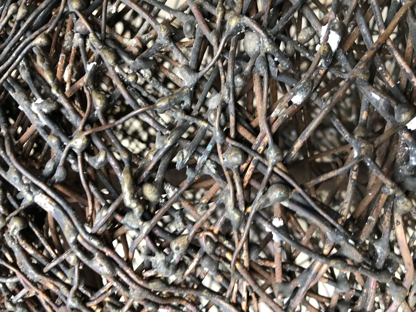 Escultura antiga com linhas entrelaçadas e texturizadas.