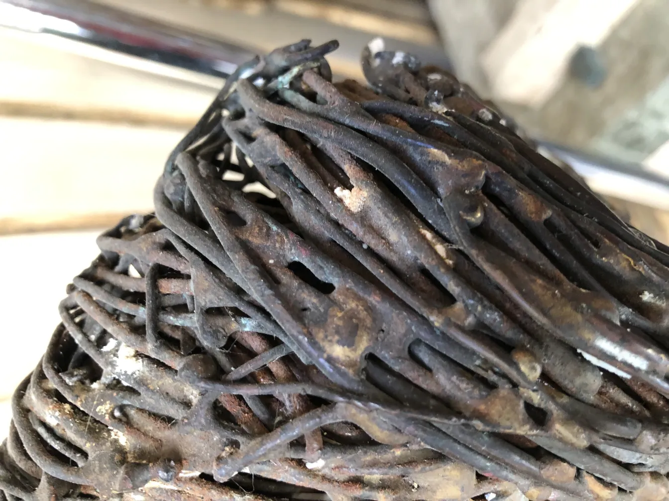 प्राचीन मूर्ति जिसमें स्पष्ट अमूर्त विवरण हैं, लकड़ी से घिरी हुई।