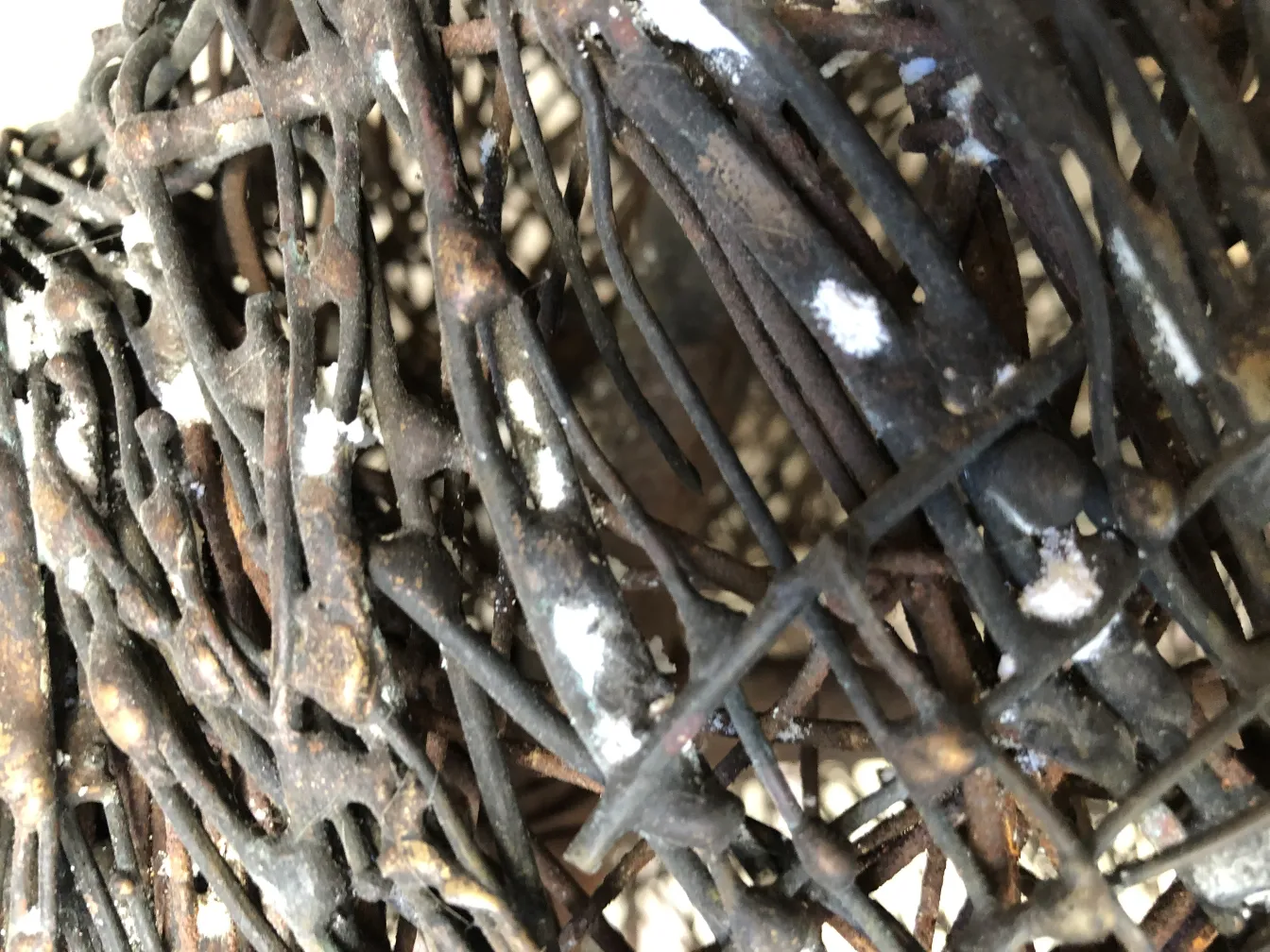 Sculpture antique avec des formes organiques entrelacées et des détails subtils.