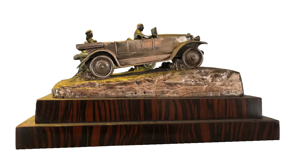 Escultura antigua de un carro con dos personas sobre una base