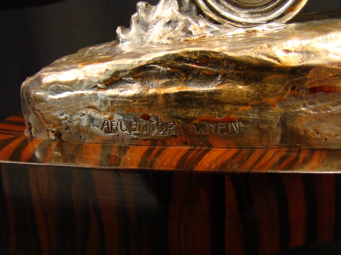 Scultura antica decorativa con dettagli in argento e legno.