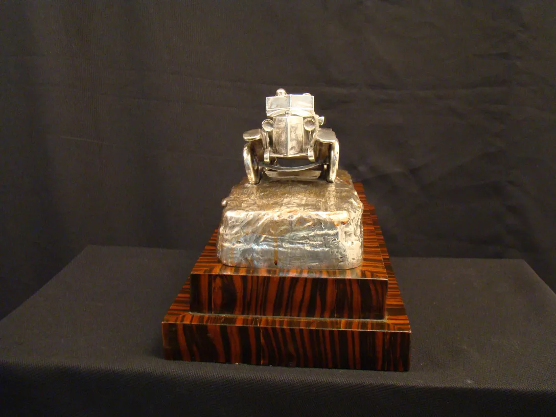 escultura antiga de um carro em uma base decorativa