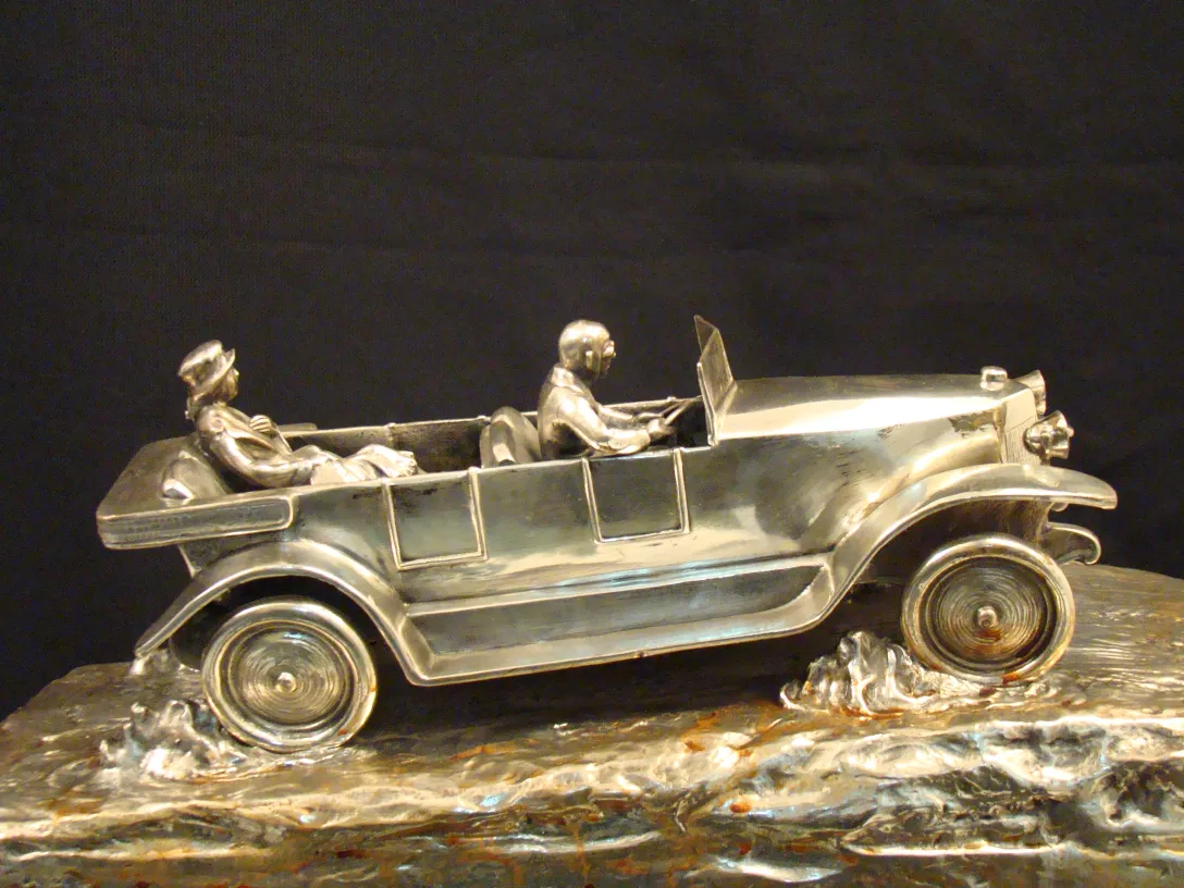 antike skulptur eines autos mit sitzenden figuren in miniatur