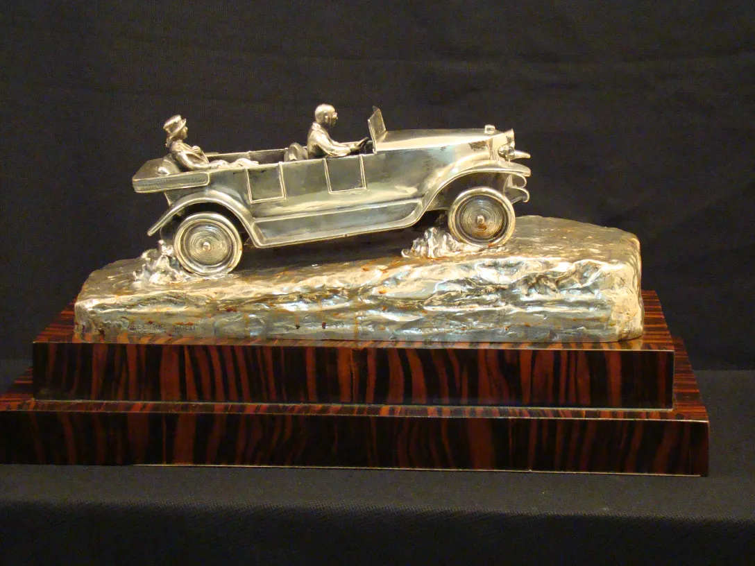 Antique sculpture of a vehicle with two figures inside
