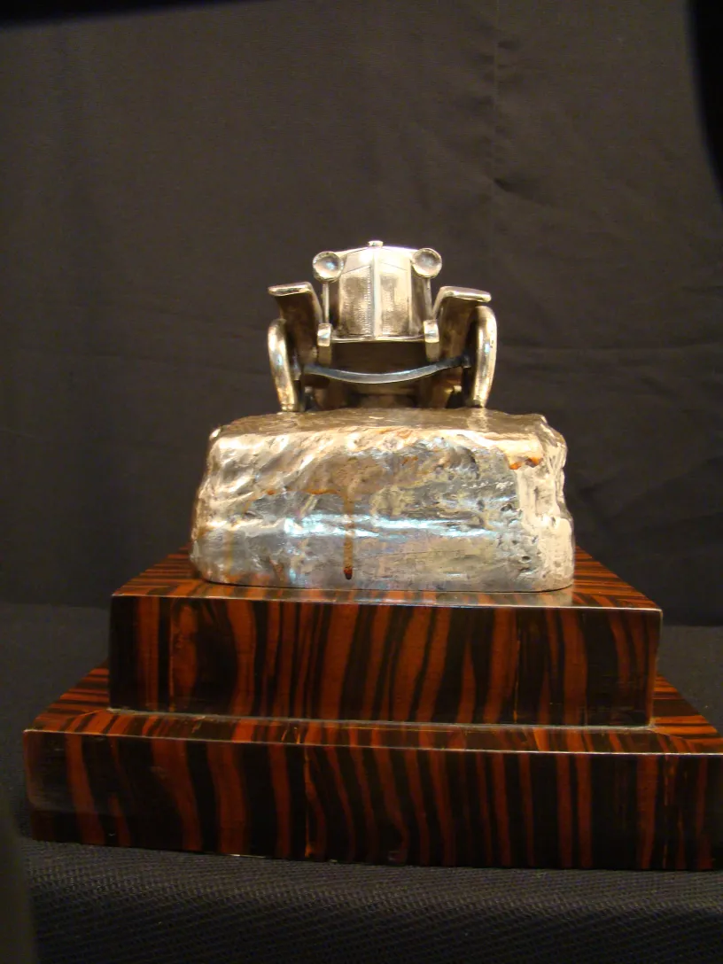 antique sculpture of a car on an elegant base