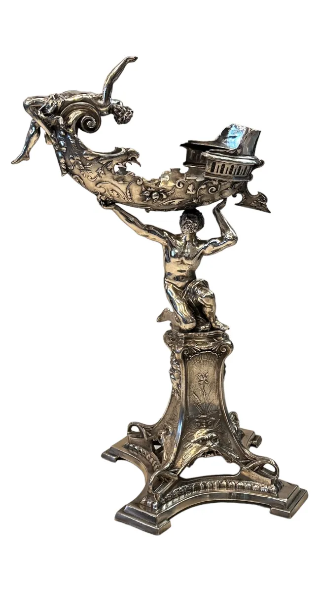 escultura antigua decorativa con figuras humanas en metal brillante