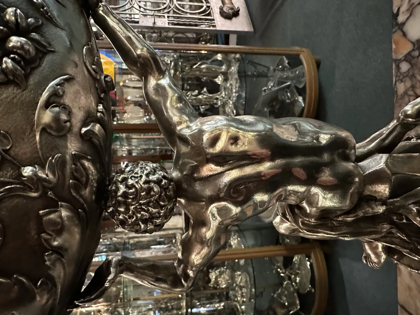 Antike Skulptur einer menschlichen Figur mit ornamentalen Details.