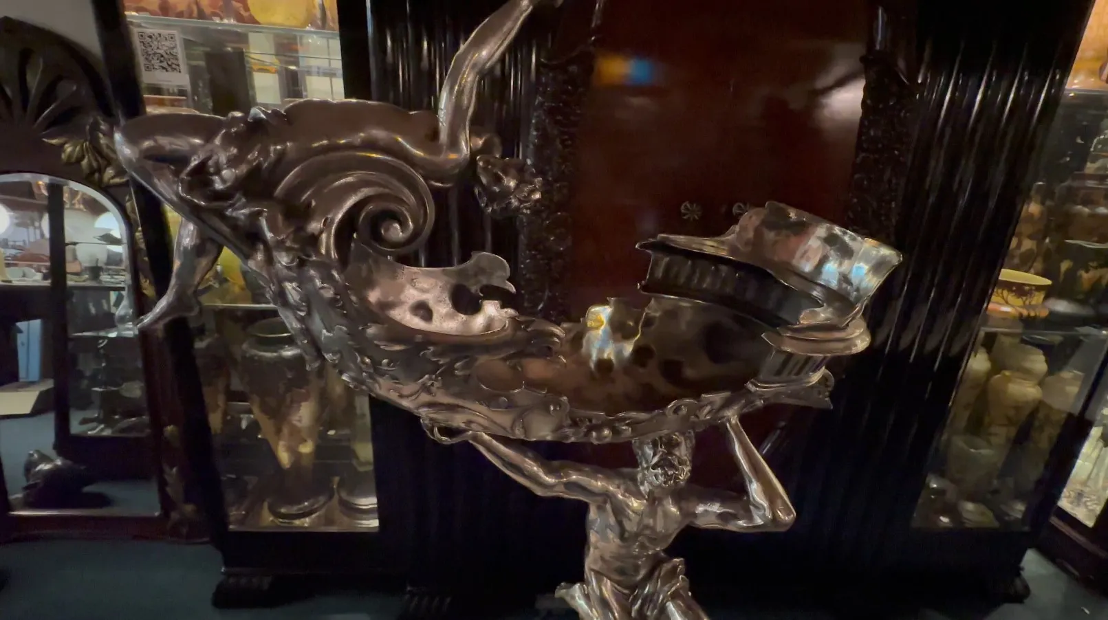 Antike Skulptur mit männlicher Figur, die eine dekorative Schale hält