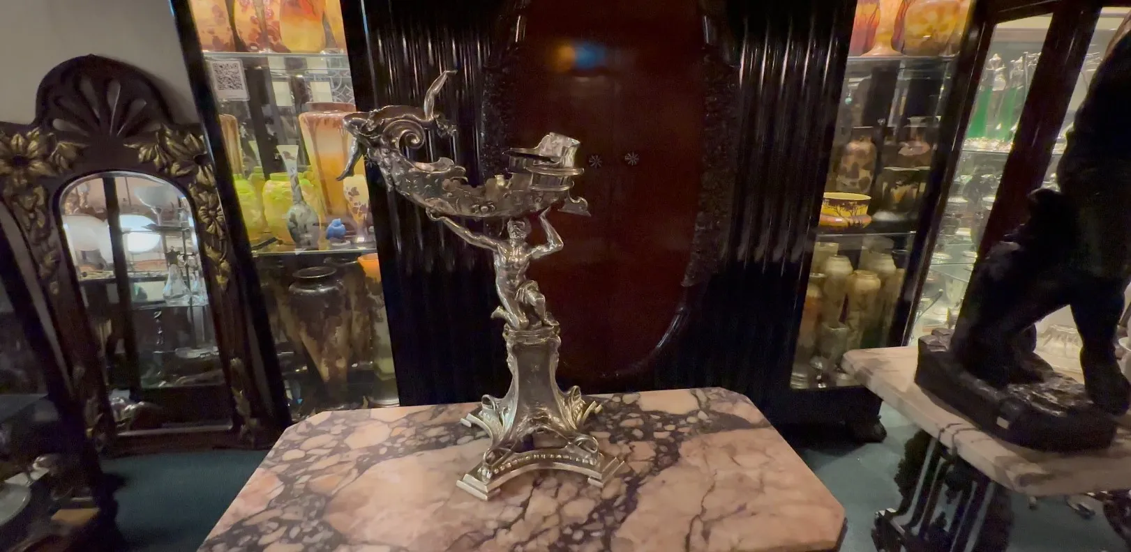 elegante antike dekorative Skulptur mit komplizierten Details, umgeben von verschiedenen Antiquitäten