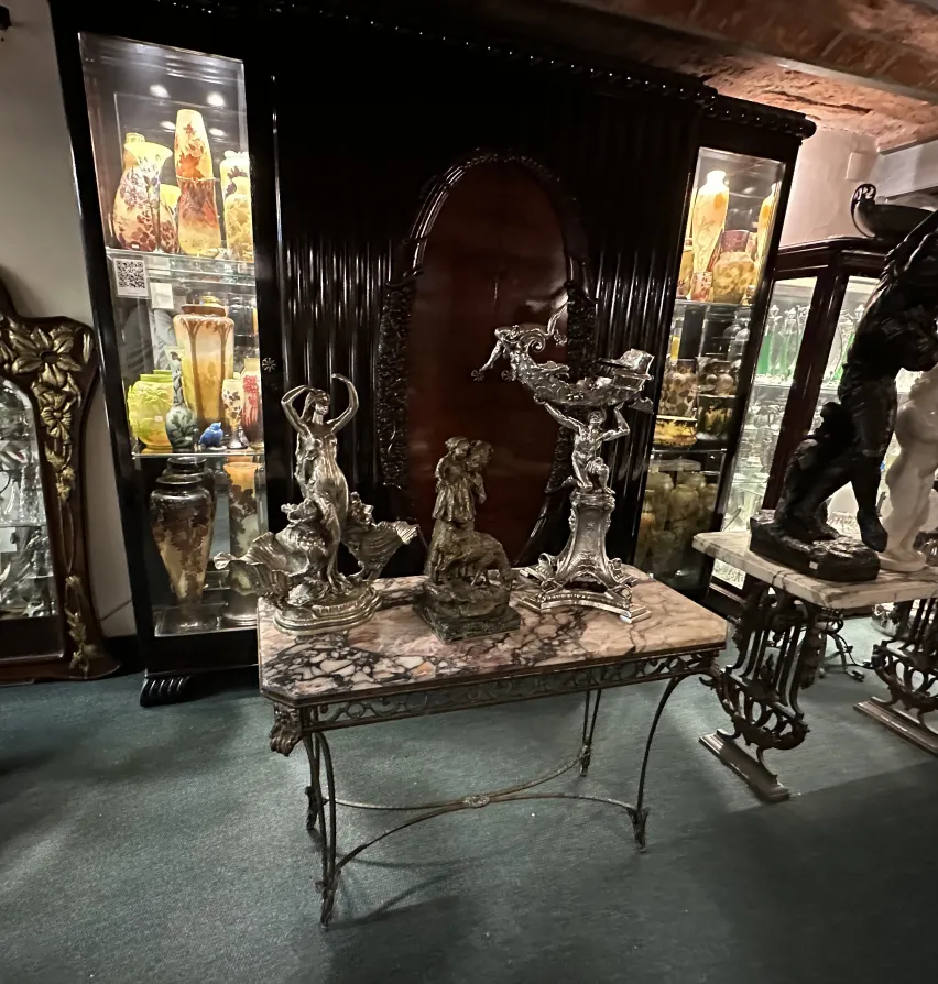 Scultura antica su tavolo di marmo in stanza con vetrine