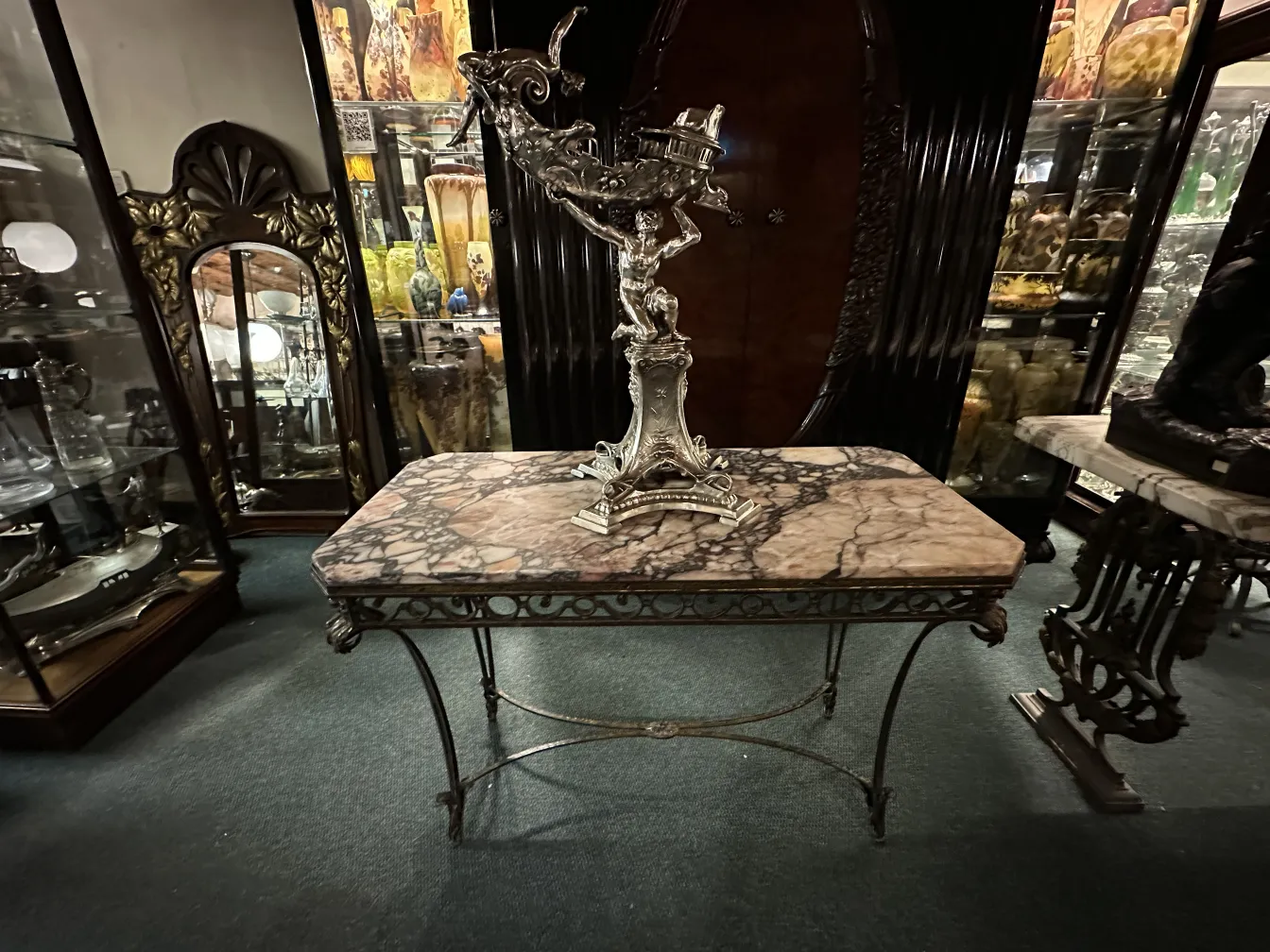 Scultura antica decorativa in un ambiente elegante, con tavoli e vetrine.