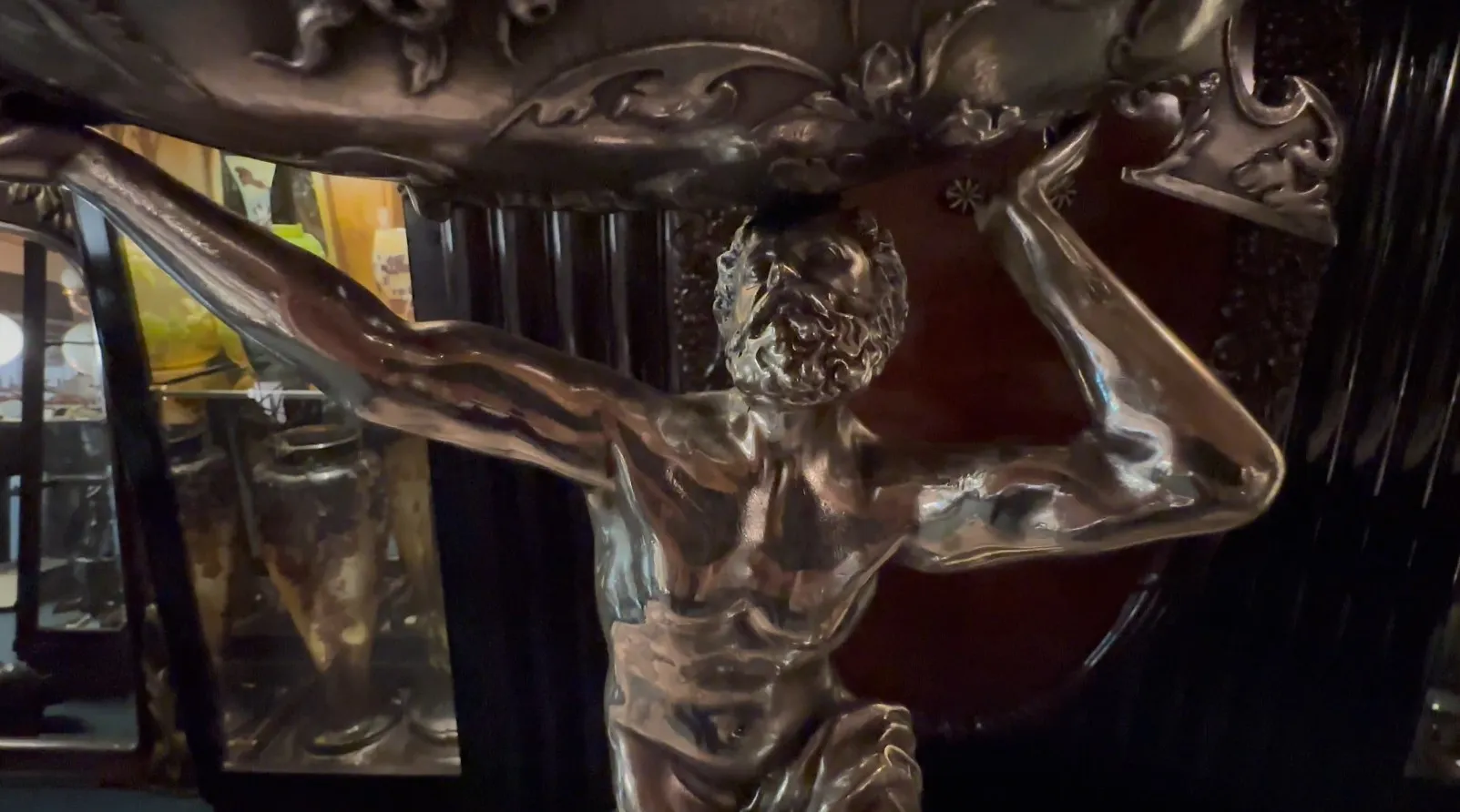 escultura antigua de un hombre levantando un peso, en un entorno acogedor