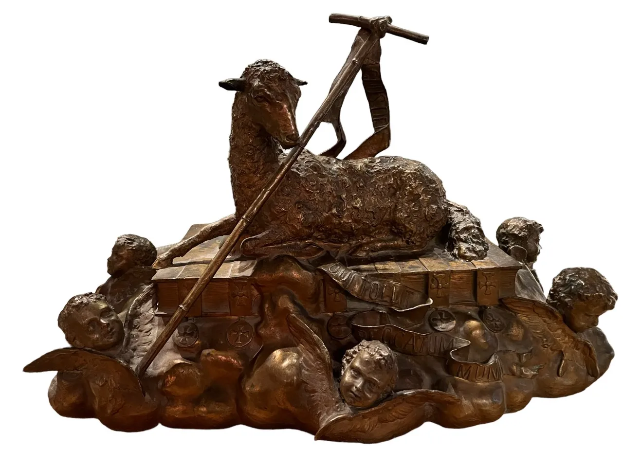 Sculpture ancienne d'un agneau entouré de figures angéliques.