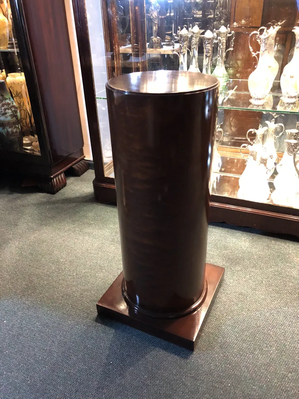 Antique cylindrical column, background with display cases