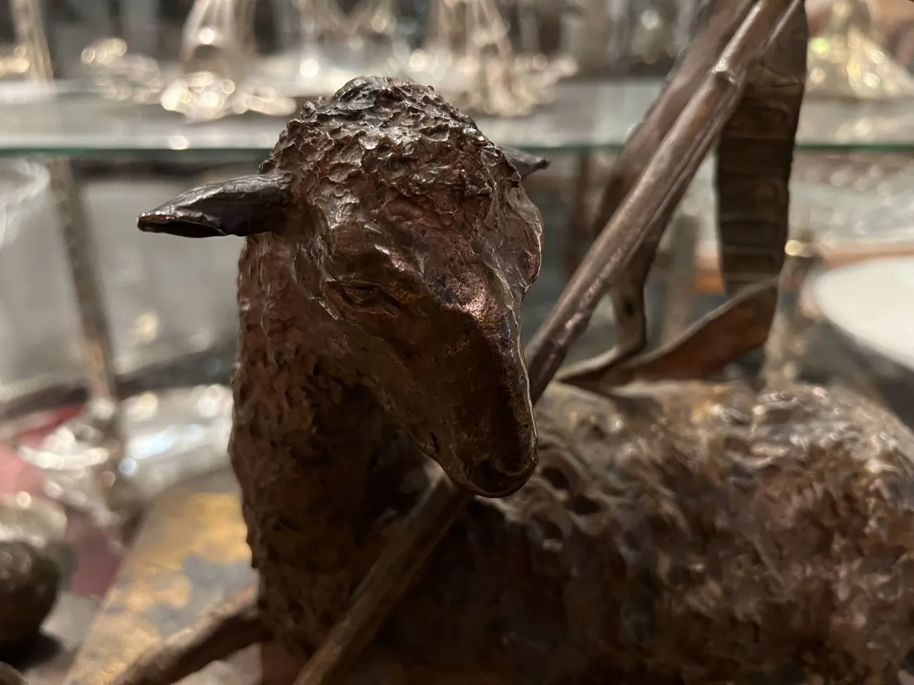 텍스처가 있는 고대 양 조각상과 활이 특징입니다.