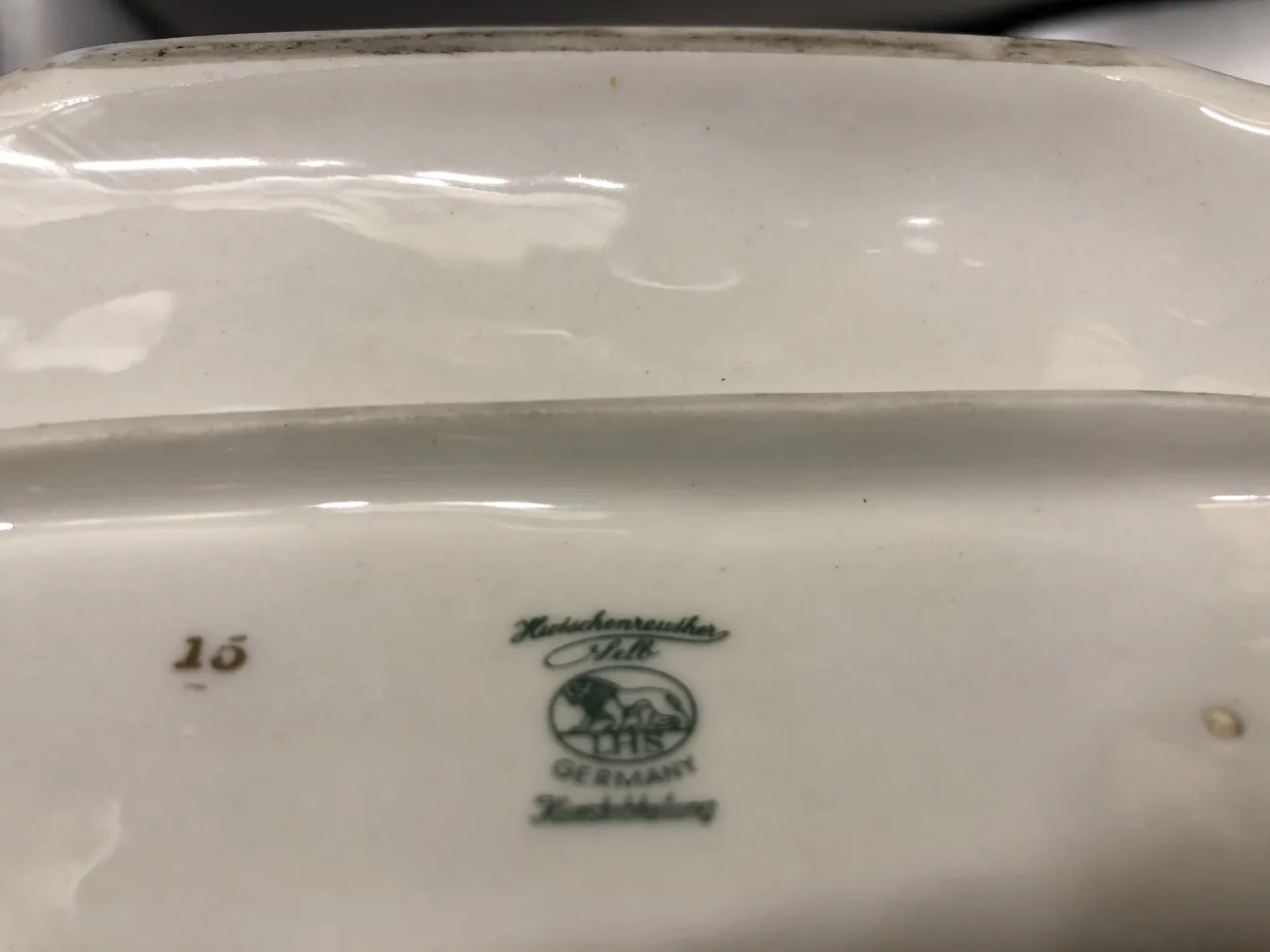 Antica ceramica con dettagli verdi e marchi visibili.