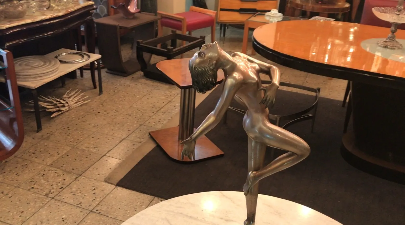 escultura antiga de figura humana em movimento, ambiente elegante