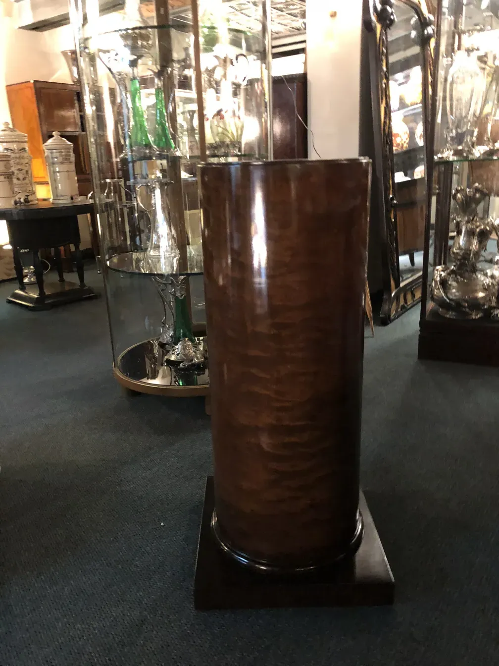 Colonna antica in legno con finitura lucida in un'ambientazione di antiquariato.