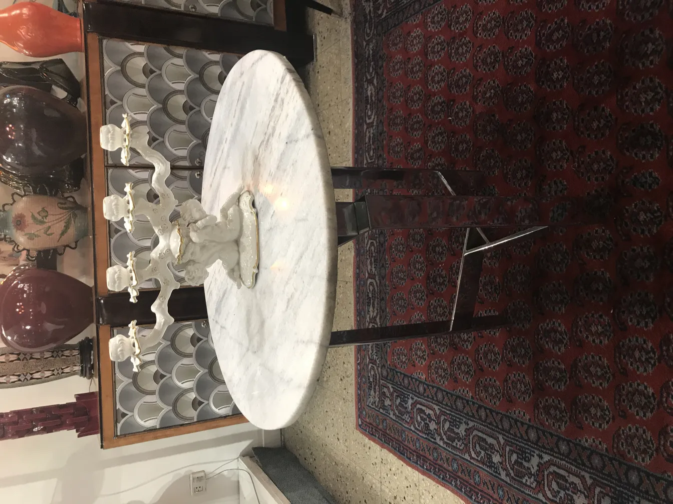 Antique ceramic candelabra on decorative table.