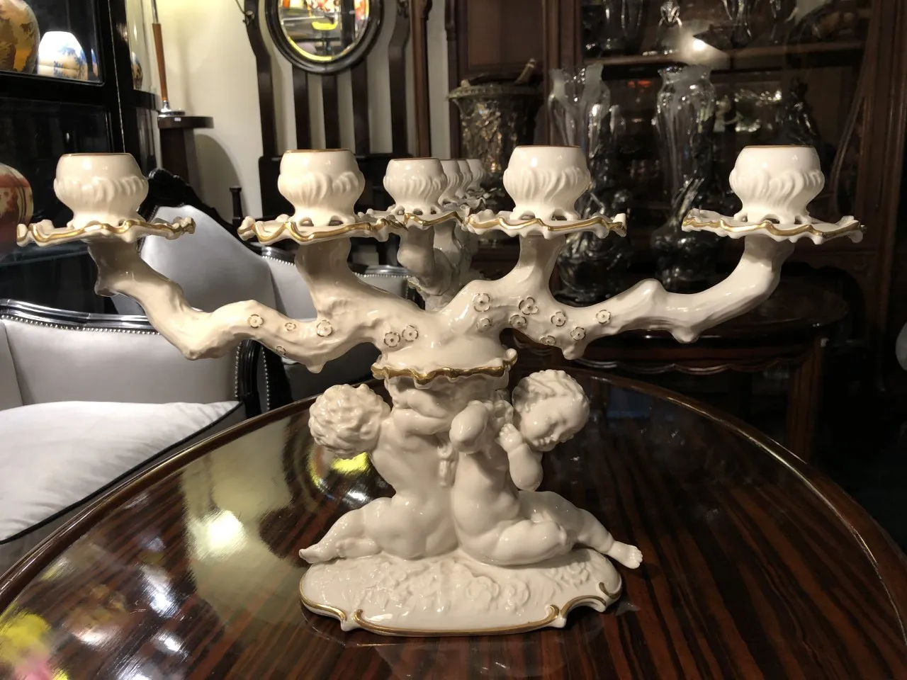 Candelabro ornamental de cerámica antigua con detalles decorativos.