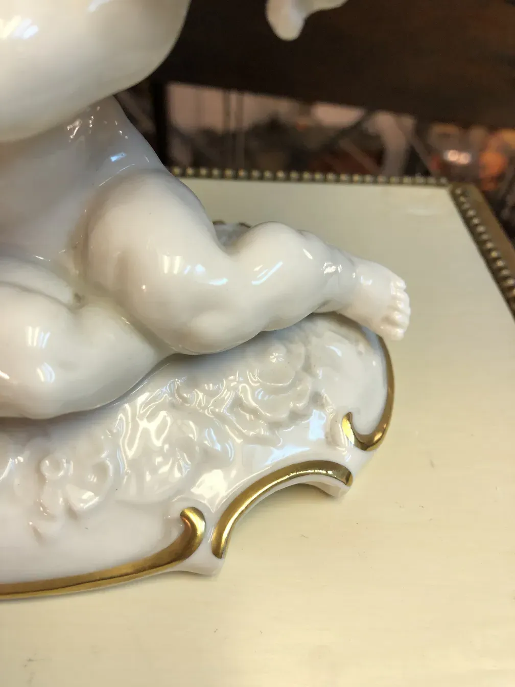 Detalle de una antigüedad de cerámica con acabado brillante y base decorativa.