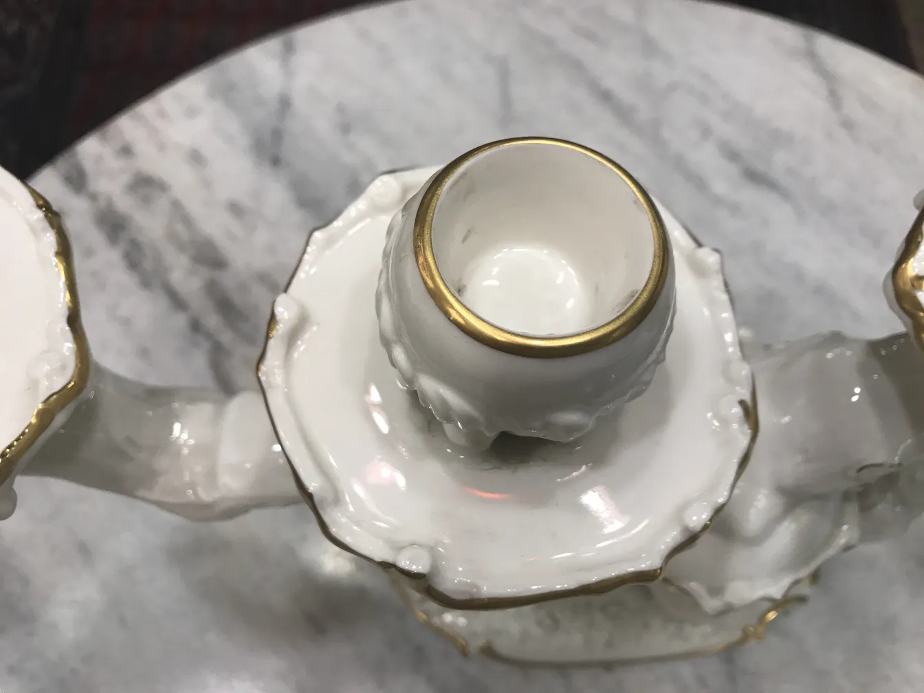 Candelabro antico in ceramica con dettagli dorati.