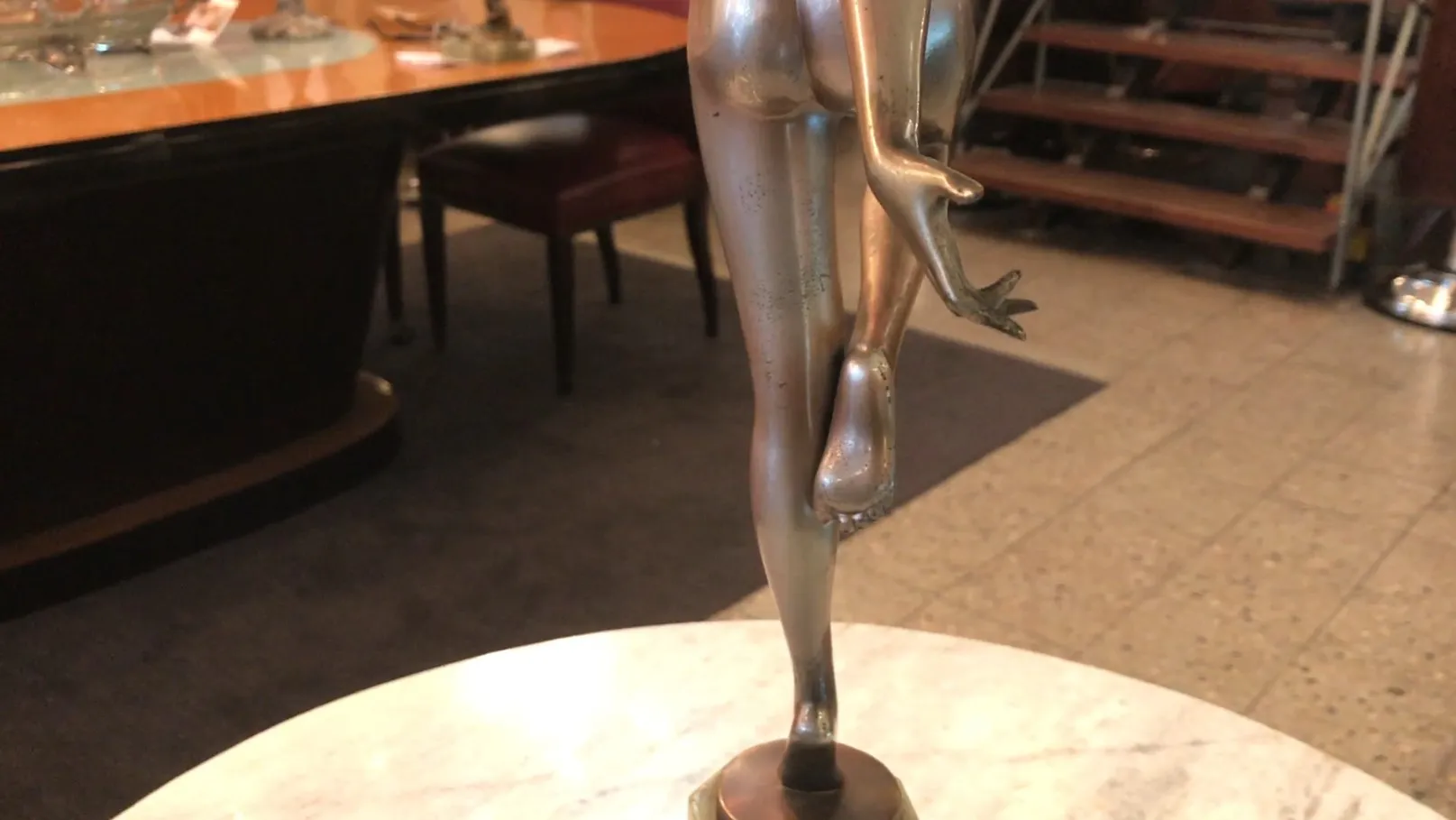 Scultura antica con figura in posa elegante su piedistallo