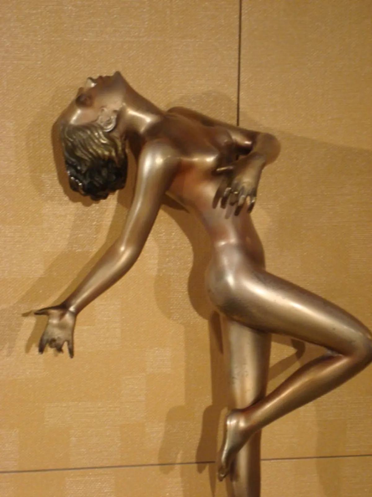 Ancient sculpture of human figure with shiny details