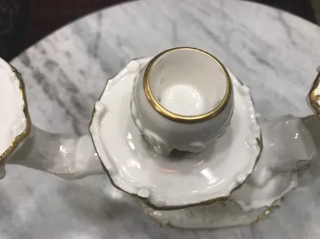 Antike Kerzenhalter aus Keramik mit goldenen Akzenten auf Marmor.