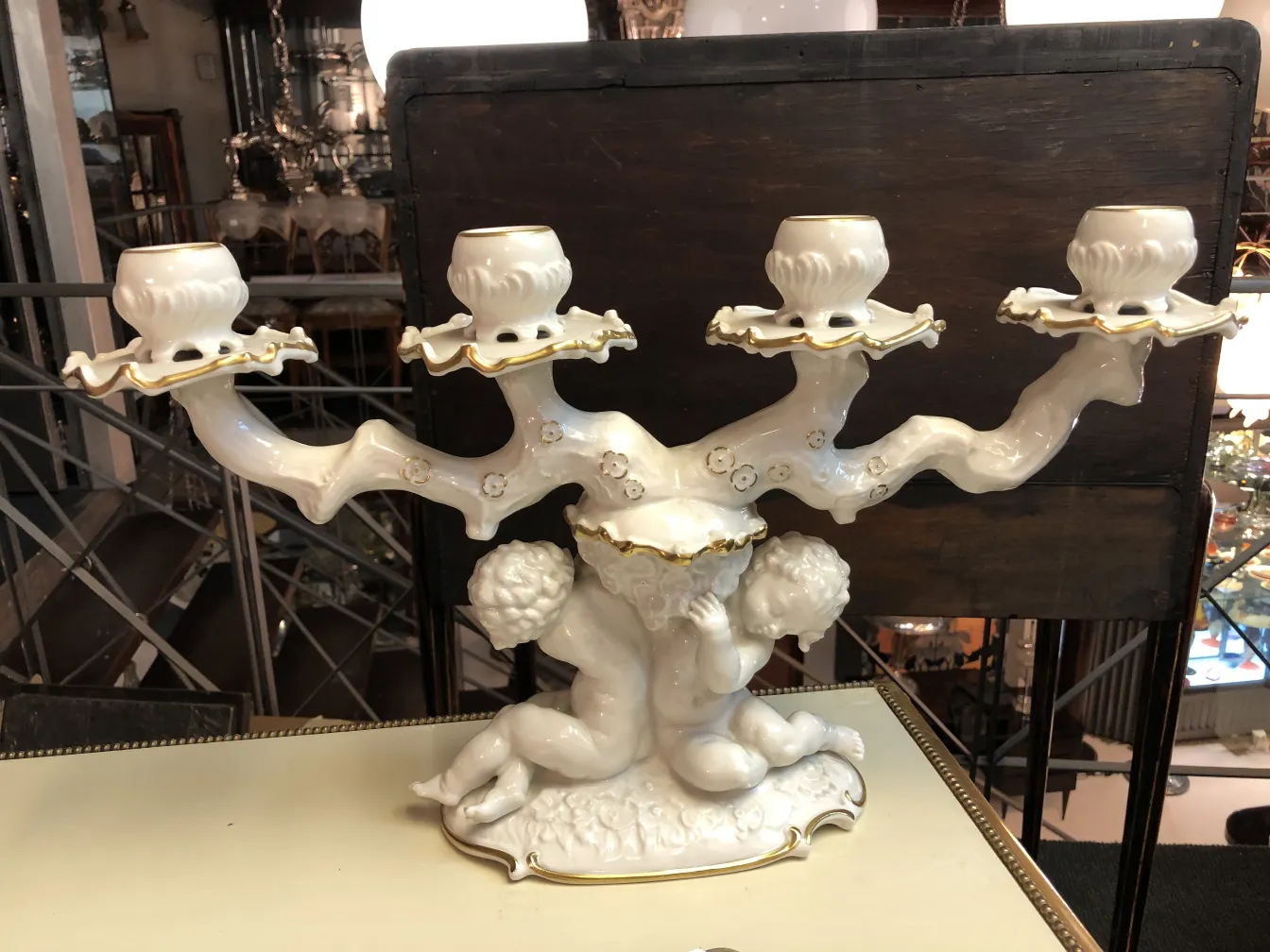 Candelabro antico in ceramica con dettagli dorati e figure di bambini