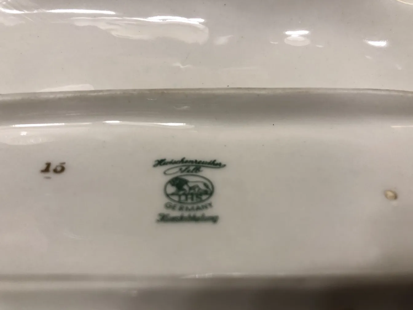 Piatto in ceramica antico, con design verde e marchio tedesco.