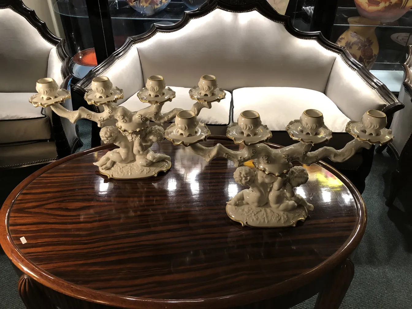 Due candelabri antichi in ceramica con dettagli dorati, design elegante.