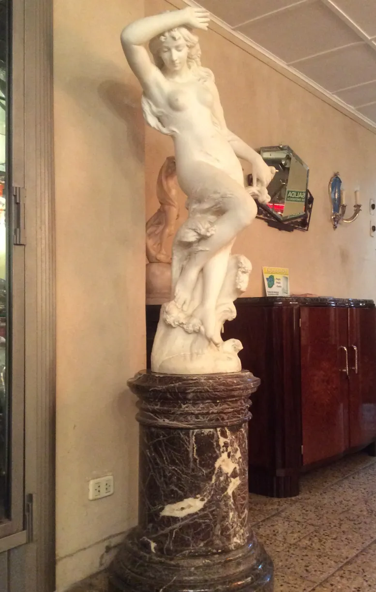 escultura antigua con figura femenina detallada, ambiente clásico