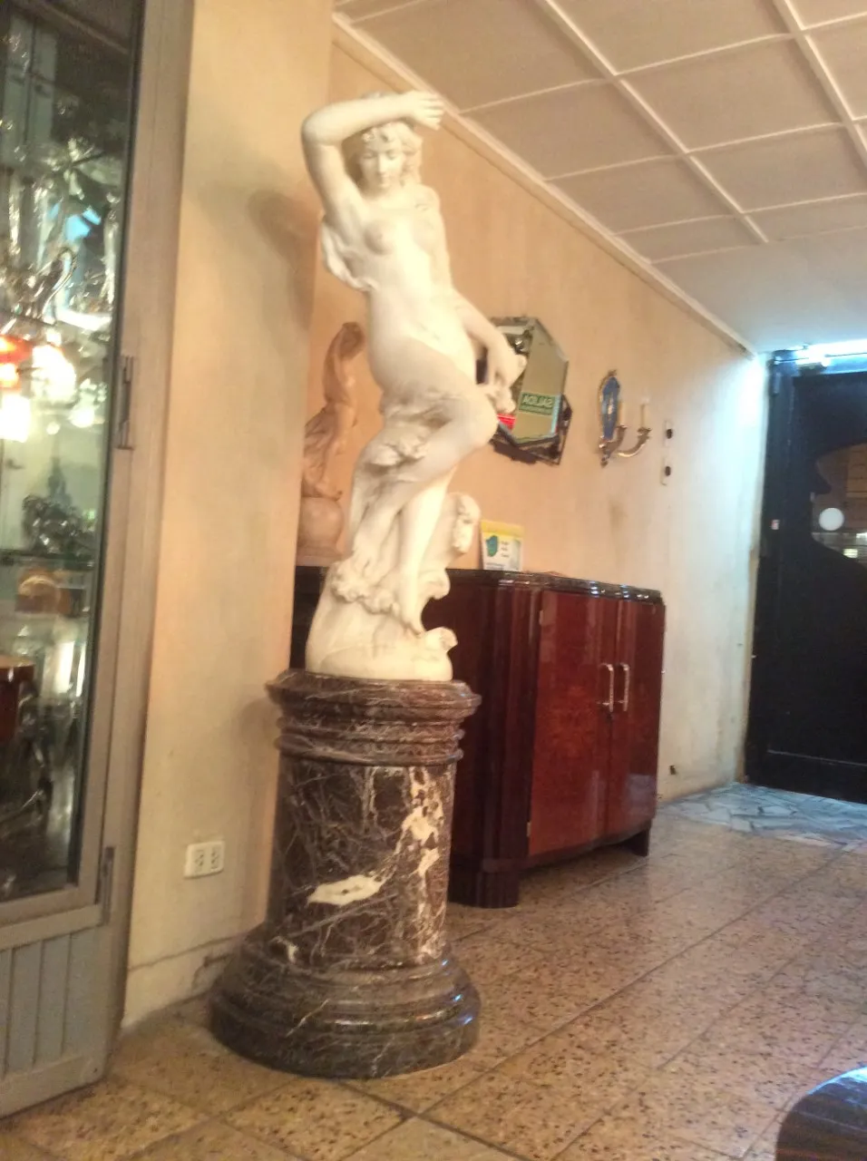 sculpture ancienne avec une figure féminine et une base ornée