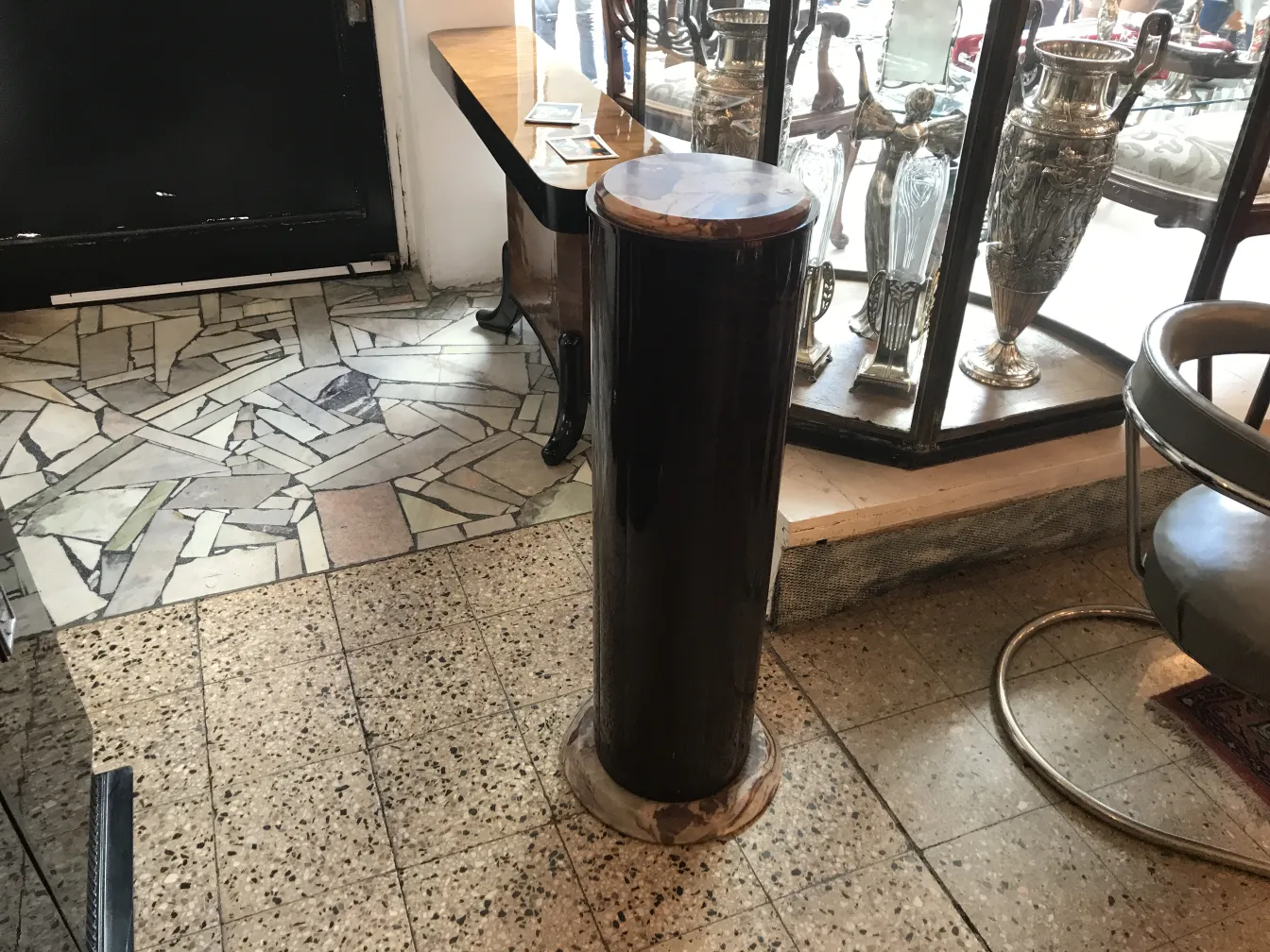 Coluna decorativa antiga, situada em um ambiente elegante.