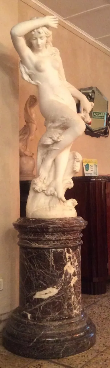 scultura antica con figura femminile in posa dinamica