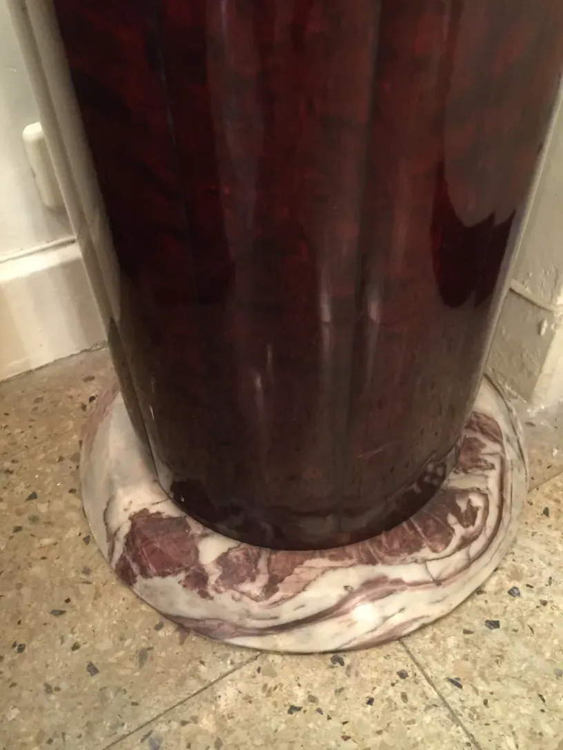 coluna antiga de cor escura com base decorativa