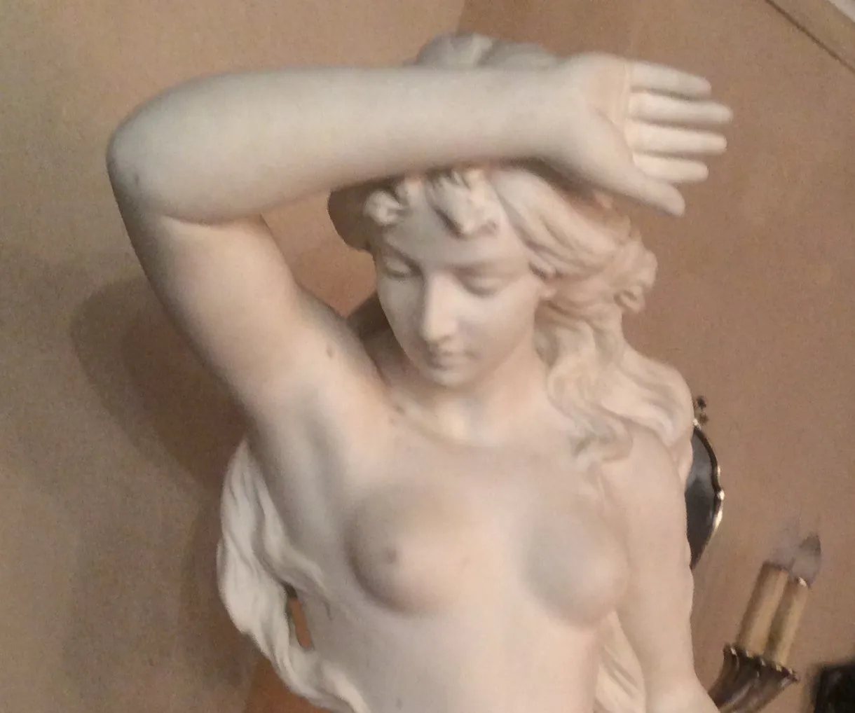 escultura antigua de figura femenina con detalles elegantes