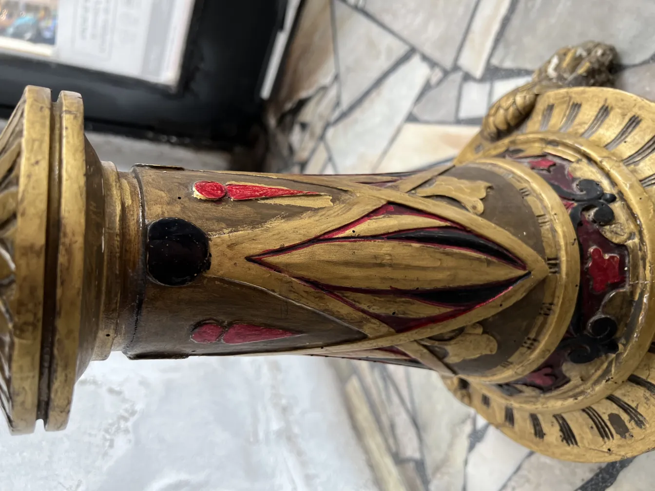 Escultura antiga com detalhes decorativos em dourado e vermelho