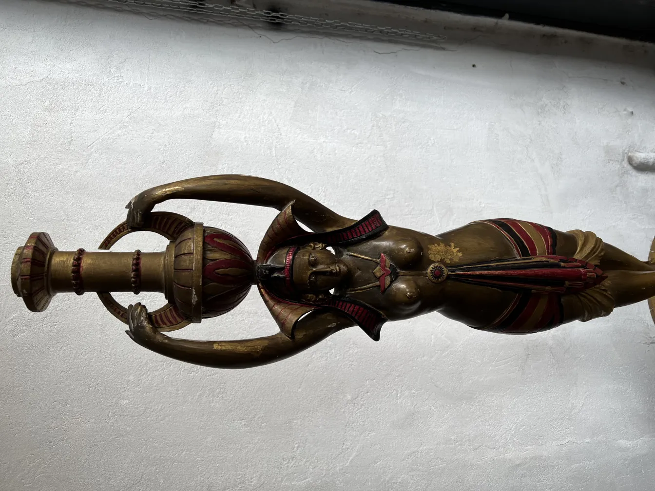 Escultura antiga de mulher segurando um objeto decorativo